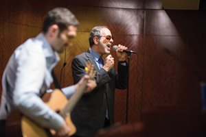 Barry Horwitz (left) and Michael Strom entertain the crowd gathered during the Decalogue Society of Lawyers and Jewish Judges Association Hanukkah Party. 
