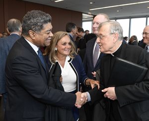 Cook County Circuit Chief Judge Timothy C. Evans and newly sworn-in Catholic Lawyers Guild of Chicago President Pamela Sakowicz Menaker, communications partner at Clifford Law Offices, greet the Very Rev. Greg Sakowicz. Sakowicz, the rector and pastor at Holy Name Cathedral and Menaker’s brother, did the invocation at the guild’s swearing-in ceremony May 1 at the offices of Jenner & Block. Illinois Supreme Court Justice Thomas Kilbride (in background) swore in the board members, Evans swore in the officers and Illinois Supreme Court Justice Anne Burke (not pictured) swore in Menaker.